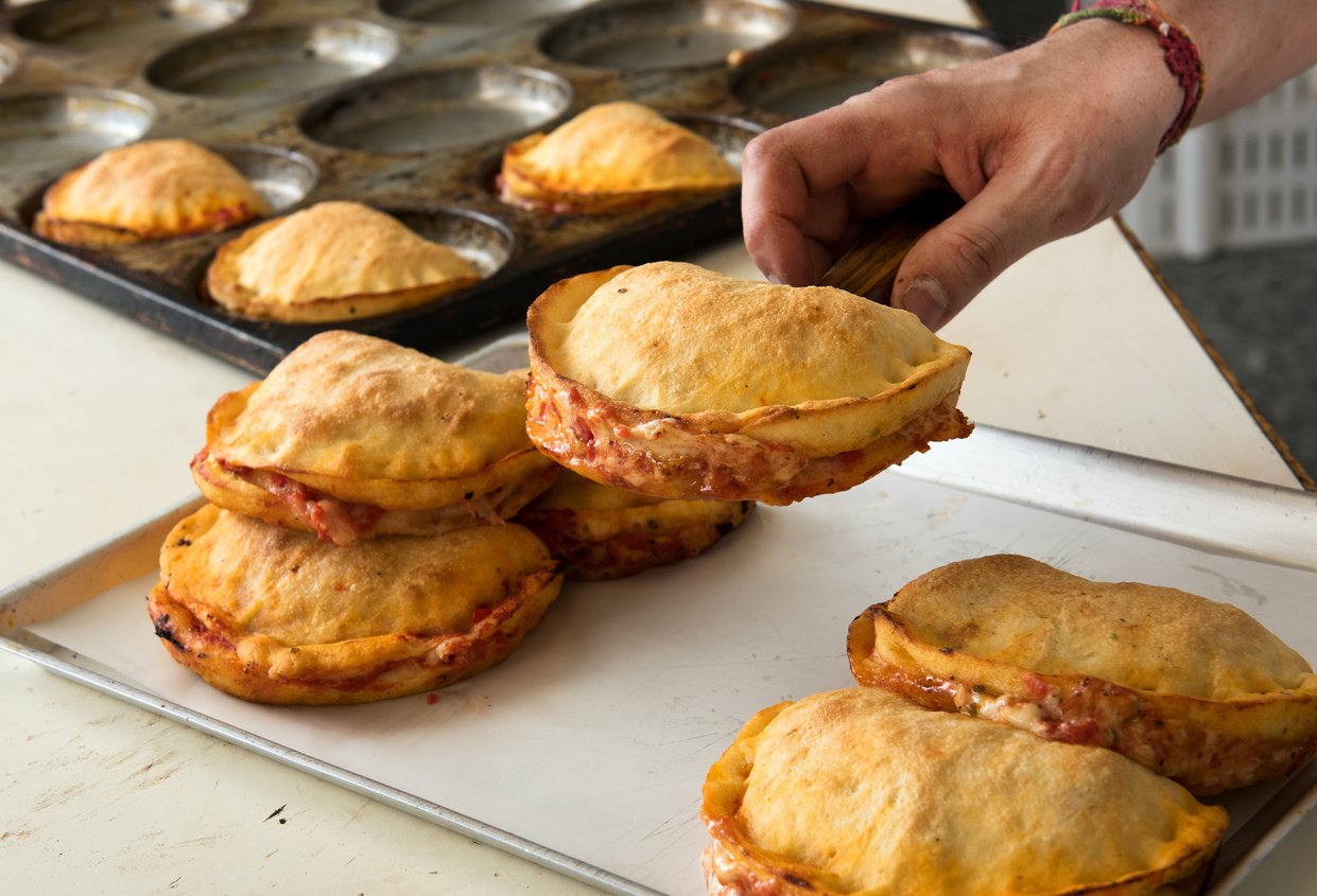 Person Serving Fresh Panzerotti on a Tray